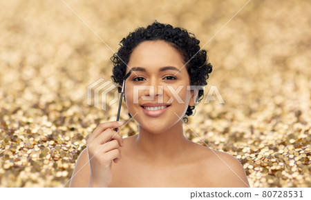 smiling african american woman with mascara brush smiling african american woman with mascara brush 80728531