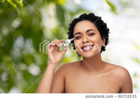 happy young african american woman with eye drops happy young african american woman with eye drops 80728535