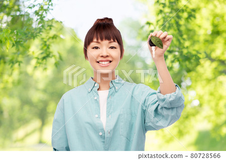 happy asian woman holding car key with green leaf 80728566