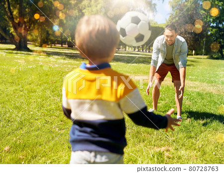 father with little son playing soccer at park father with little son playing soccer at park 80728763