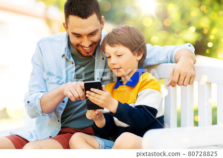 father and son with smartphone at park 80728825