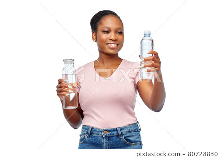 happy woman with plastic and glass bottle of water 80728830