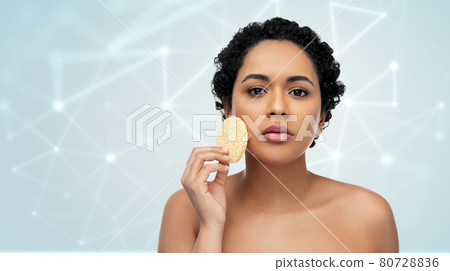 young woman cleaning face with exfoliating sponge young woman cleaning face with exfoliating sponge 80728836