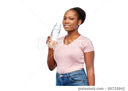 happy african woman drinks water from glass bottle happy african woman drinks water from glass bottle 80728842