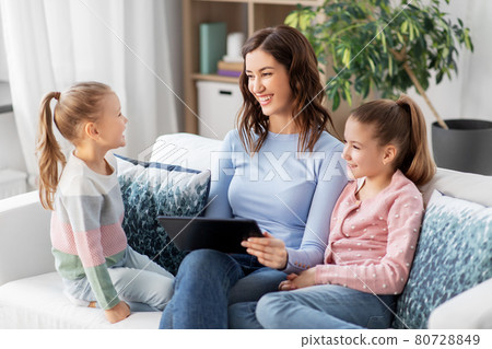 happy mother and daughters with tablet pc at home happy mother and daughters with tablet pc at home 80728849