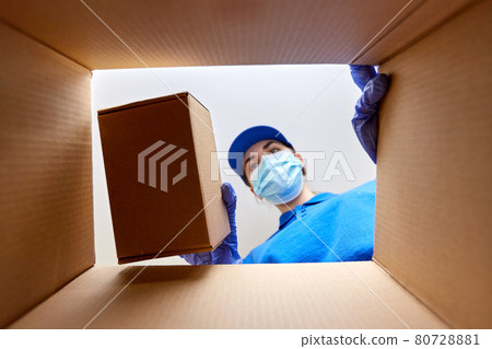 woman in mask packing box to parcel 80728881