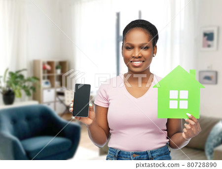 african woman with smartphone and green house 80728890