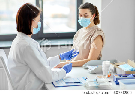 female doctor with syringe vaccinating patient female doctor with syringe vaccinating patient 80728906