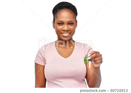 african woman holding car key with green leaf 80728913