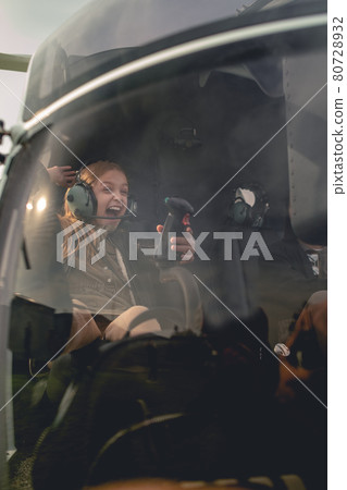 Excited tween girl sitting on co-pilot seat in helicopter Excited tween girl sitting on co-pilot seat in helicopter 80728932