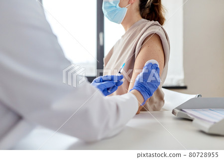 female doctor with syringe vaccinating patient female doctor with syringe vaccinating patient 80728955