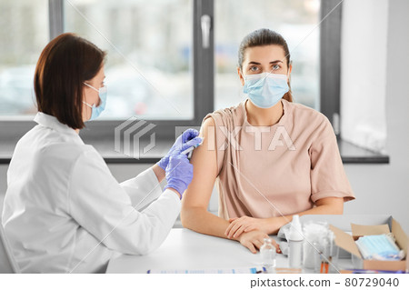female doctor with syringe vaccinating patient female doctor with syringe vaccinating patient 80729040