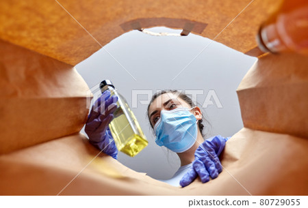 woman in gloves and mask with food in paper bag woman in gloves and mask with food in paper bag 80729055