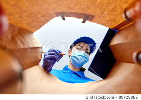 delivery girl in gloves and mask with food in bag delivery girl in gloves and mask with food in bag 80729069
