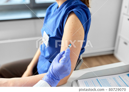 doctor with syringe vaccinating medical worker doctor with syringe vaccinating medical worker 80729070