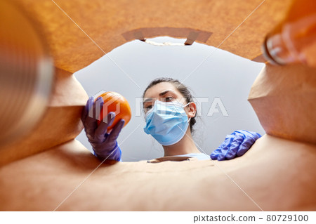 woman in gloves and mask with food in paper bag woman in gloves and mask with food in paper bag 80729100