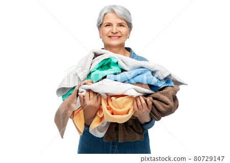 smiling senior woman with heap of bath towels smiling senior woman with heap of bath towels 80729147