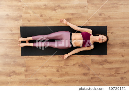 woman doing yoga corpse pose at studio woman doing yoga corpse pose at studio 80729151