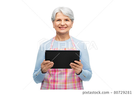 smiling senior woman in apron with tablet computer 80729281