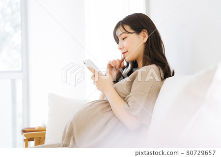 Pregnant women using smartphones 80729657
