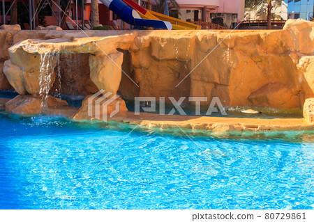 Beautiful small waterfall in the swimming pool Beautiful small waterfall in the swimming pool 80729861