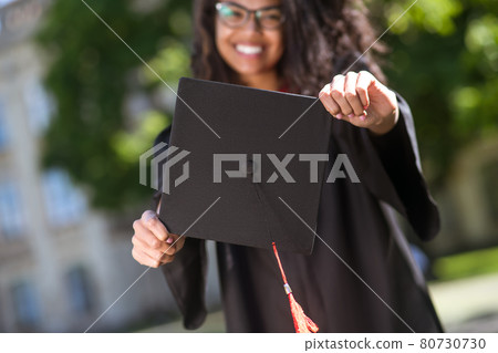 Dark-haired graduate feeling happy and excited about graduation 80730730