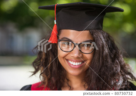 Dark-haired graduate feeling happy and excited about graduation Dark-haired graduate feeling happy and excited about graduation 80730732