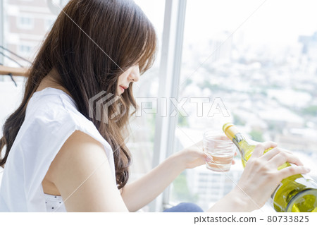 Woman drinking alcohol in a hammock Woman drinking alcohol in a hammock 80733825