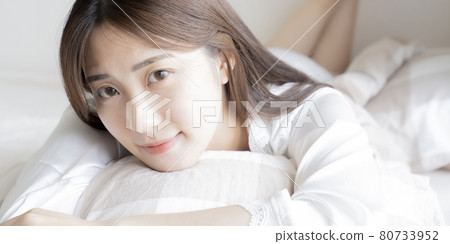 Woman lying on bed 80733952