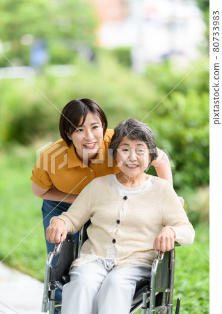 Senior women, young women, fresh green care, smiles, wheelchairs 80733983