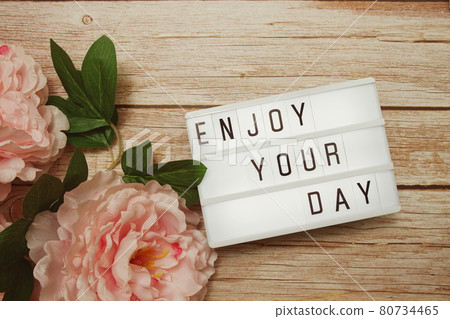 Enjoy Your Day text on lightbox on wooden background Enjoy Your Day text on lightbox on wooden background 80734465