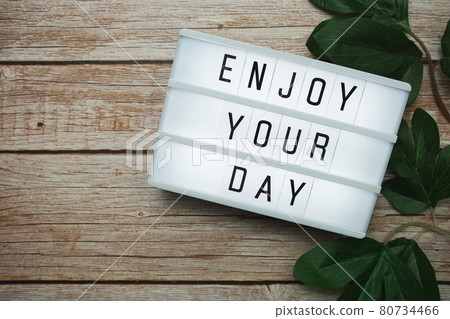 Enjoy Your Day text on lightbox on wooden background 80734466