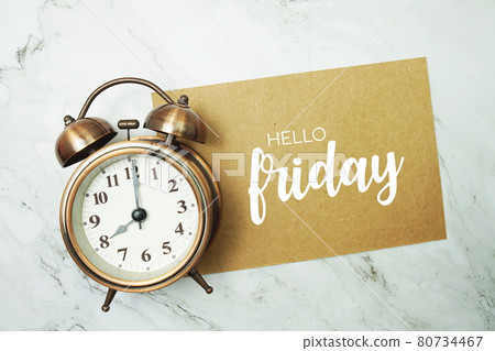 Hello Friday typography text on paper card with alarm clock on marble background Hello Friday typography text on paper card with alarm clock on marble background 80734467