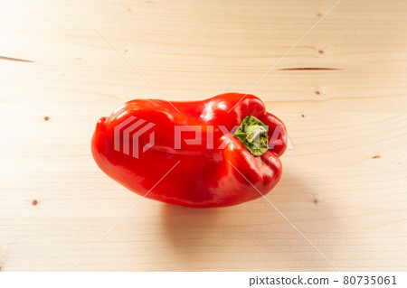 Close-up red bell pepper on a wooden background. Fresh red pepper is organic vegetable, top view. Vitamin red product, minimum calorie content. High quality photo Close-up red bell pepper on a wooden background. Fresh red pepper is organic vegetable, top view. Vitamin red product, minimum calorie content. High quality photo 80735061