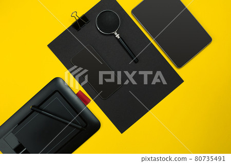 Flat lay display of business office gadgets with notepad, cup, pen, develop, glasses and etc. Top view. Black office objects on a yellow background 80735491