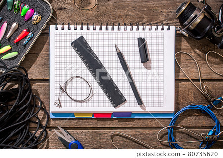 Fishing tackle - fishing spinning, fishing line, hooks and lures on wooden background. 80735620
