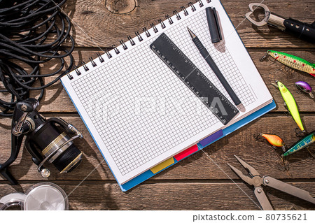 Fishing tackle - fishing spinning, fishing line, hooks and lures on wooden background. 80735621