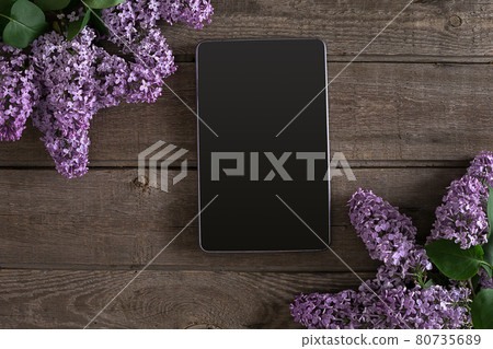 Lilac blossom on rustic wooden background, tablet with empty space for greeting message. Top view Lilac blossom on rustic wooden background, tablet with empty space for greeting message. Top view 80735689