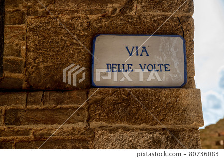 Colle di Val D'elsa, Siena, Tuscany, Italy. The vaulted street is a picturesque covered alley, a medieval passage in the old town. The street plaque. Colle di Val D'elsa, Siena, Tuscany, Italy. The vaulted street is a picturesque covered alley, a medieval passage in the old town. The street plaque. 80736083