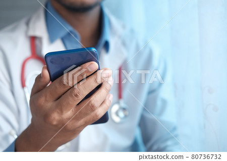 doctor in white coat using a smartphone. doctor in white coat using a smartphone. 80736732