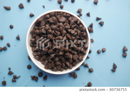 Chocolate chips spilling from a plastic packet, 80736755
