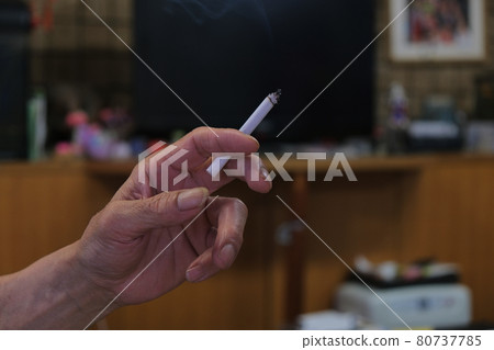 男性手拿著香煙吸煙者在房間裡吸煙的圖片照片材料 80737785