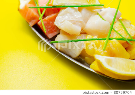 Fish pie mix, defrosted, skinless and boneless cod, dyed smoked haddock and salmon on the yellow background 80739704