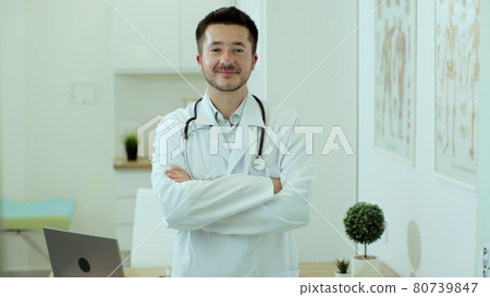 Young man doctor wear white medical uniform and stethoscope looking at camera, male professional medic physician happy face posing for close up view portrait at work in hospital. 80739847