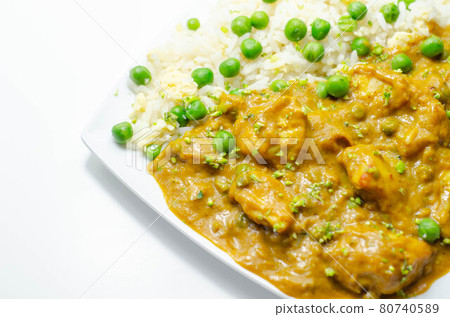 Chicken curry with egg fried rice, chicken breast pieces in a mildly spiced coconut curry sauce with fried rice with peas and egg 80740589