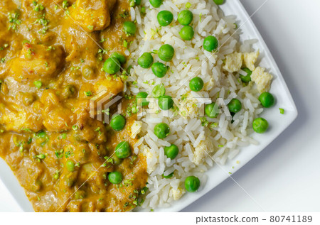 Chicken curry with egg fried rice, chicken breast pieces in a mildly spiced coconut curry sauce with fried rice with peas and egg Chicken curry with egg fried rice, chicken breast pieces in a mildly spiced coconut curry sauce with fried rice with peas and egg 80741189