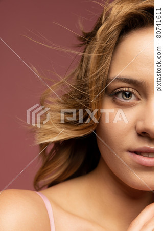 Cropped portrait of young beautiful caucasian woman isolated on brown background. Cropped portrait of young beautiful caucasian woman isolated on brown background. 80741611