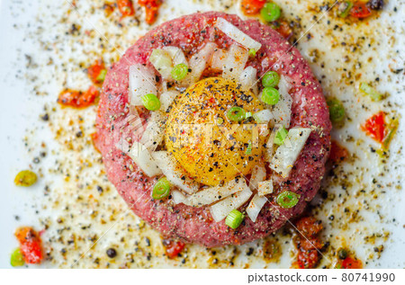 Beef steak tartare with raw egg yolk and onion with tomato 80741990