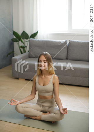 Woman in Meditation on Yoga Mat at Home 80742354