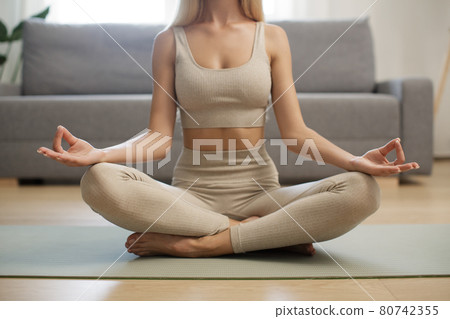 Woman in Meditation on Yoga Mat at Home Woman in Meditation on Yoga Mat at Home 80742355